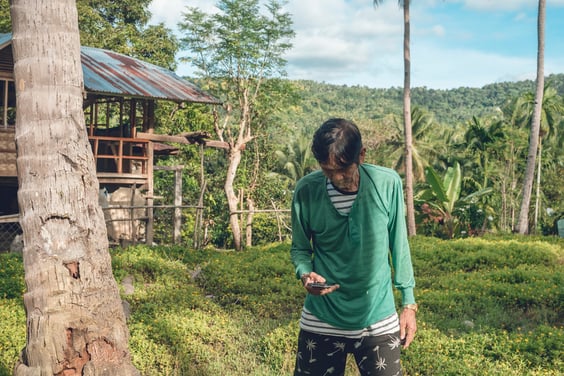 a-old-man-in-his-s-is-texting-his-son-while-at-his-rural-village-residence-good-cellphone-2094489853